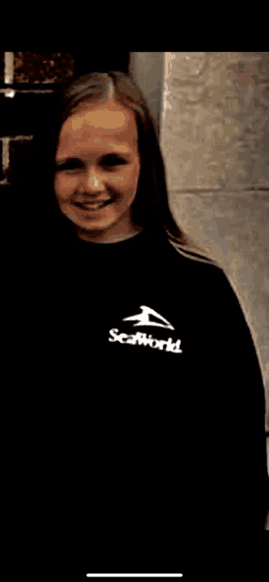 a young girl is wearing a black sweatshirt with the word seaworld on it