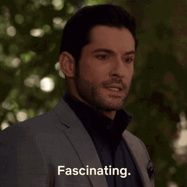 a man in a suit says fascinating in a close up