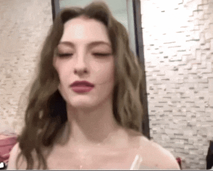 a close up of a woman 's face with her eyes closed and her mouth open .