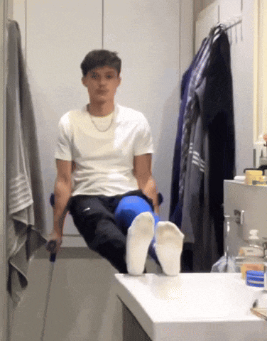 a young man with crutches is sitting on a bathroom sink