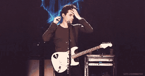 a man playing a guitar and singing into a microphone with the words gifs-johnmeyer written below him