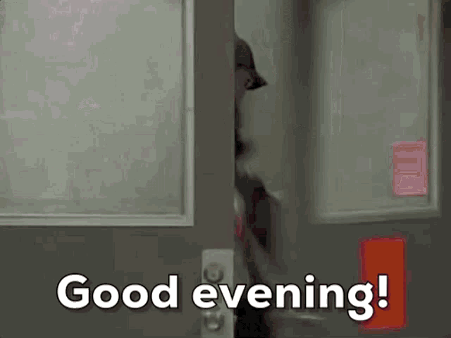 a person is opening a door with the words good evening written on it .