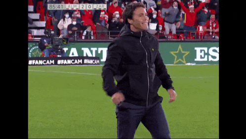 a man is dancing on a soccer field in front of a heineken banner