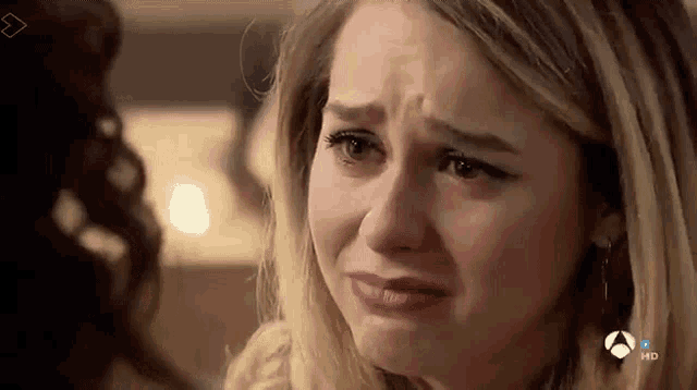 a close up of a woman 's face with a tear running down her cheek .