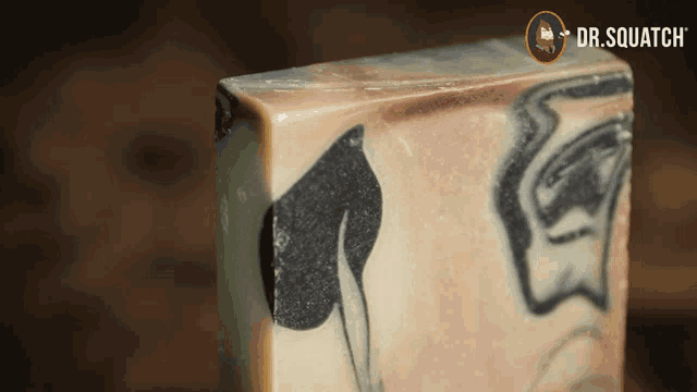 a close up of a block of soap with dr.squatch written on the bottom