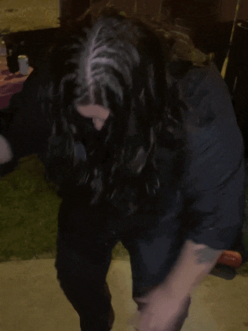 a man in a black shirt is dancing in front of a sign that says ' the bible '
