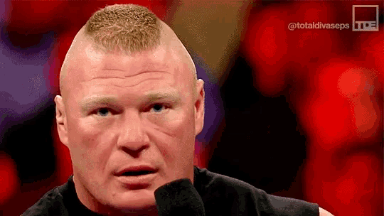a close up of brock lesnar 's face with a microphone in front of him