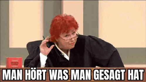 a woman in a judge 's robe is sitting in a courtroom with a pen in her hand .