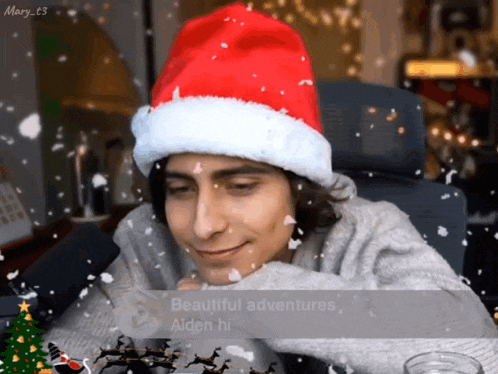a man wearing a santa hat is smiling while snow is falling