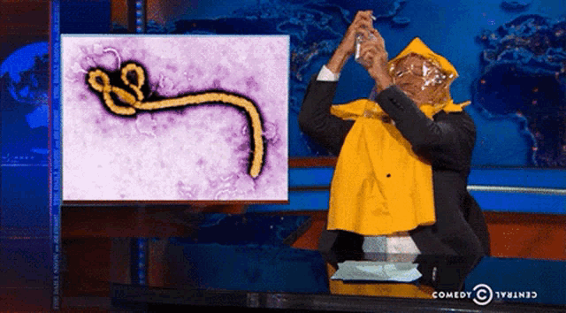 a man in a yellow cape is taking a picture of a picture of a virus