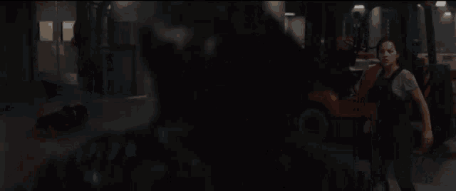 a woman is walking in a dark room with a blurred image of a person .