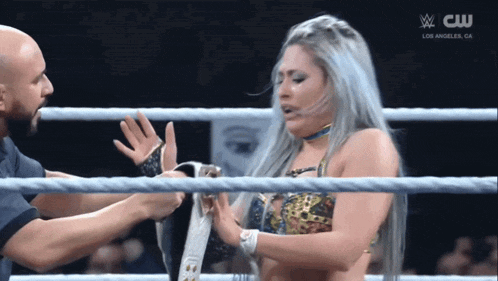 a woman in a wrestling ring with a cw logo