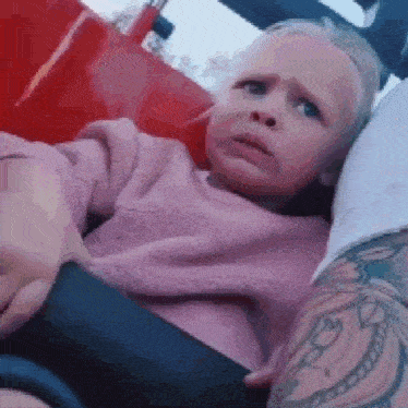 a little girl is sitting on a roller coaster with her head on a man 's lap .