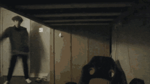 a person standing in a hallway with a shadow of a person behind them