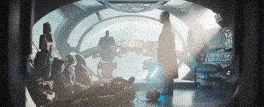 a man is standing in a room with a group of people in a spaceship .