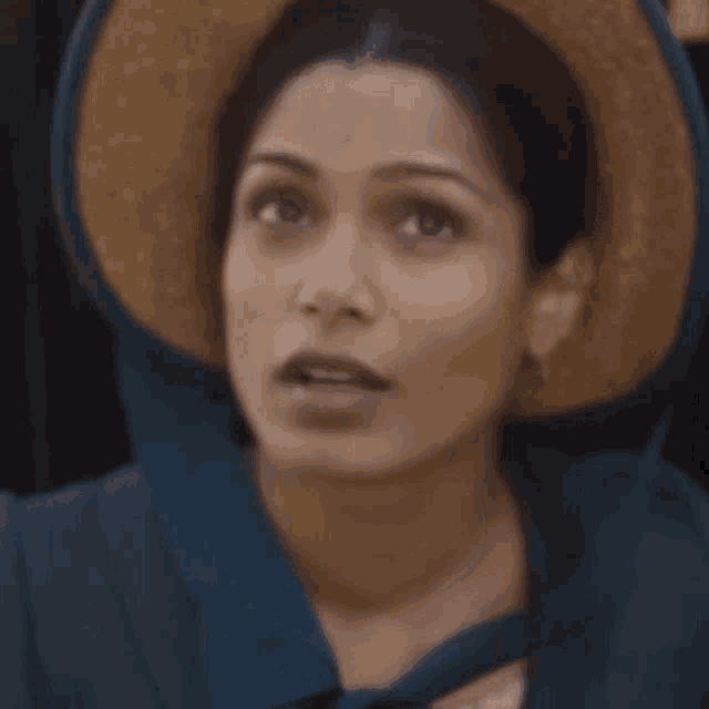 a woman wearing a straw hat and a blue shirt