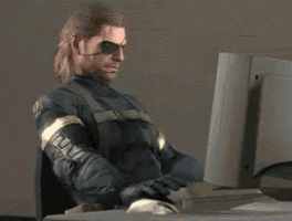 a man wearing an eye patch is sitting in front of a computer monitor .