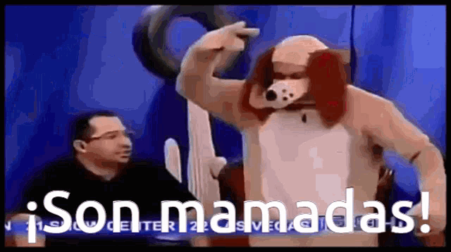 a man in a dog costume is pointing at something while another man watches .
