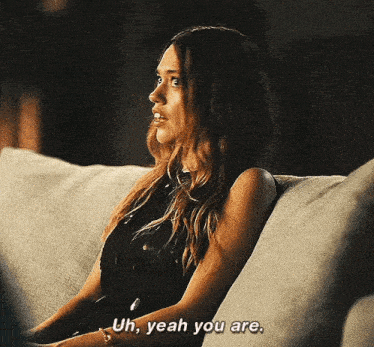 a woman is sitting on a couch and saying `` uh , yeah you are . ''