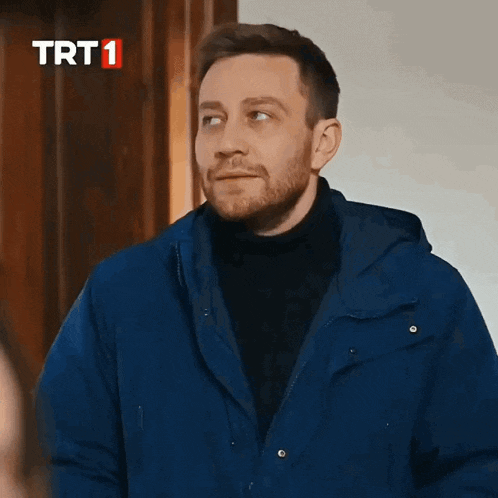 a man in a blue jacket is dancing in front of a trt1 logo
