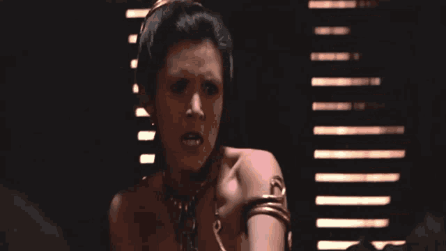 a woman wearing a chain around her neck looks angry