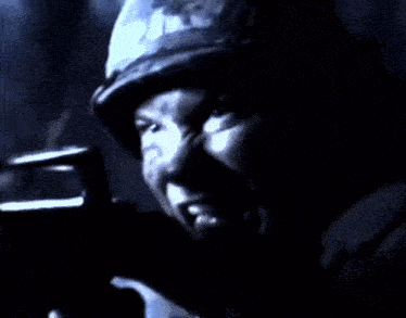 a man in a helmet is holding a gun in his hand
