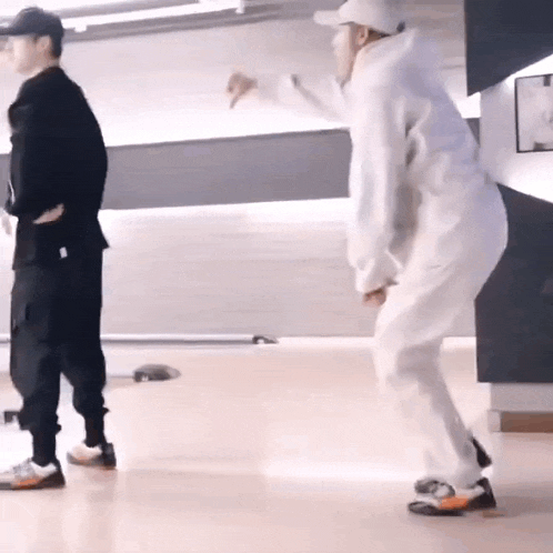 two men are standing next to each other on a dance floor .