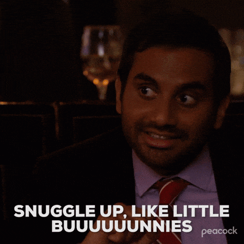 a man in a suit and tie is smiling and says " snuggle up like little buuuuunnies "