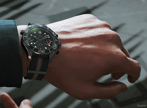 a man wearing a black omega watch on his left wrist
