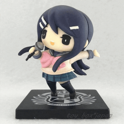 a figurine of a girl with long black hair is standing on a black base with a female symbol on it
