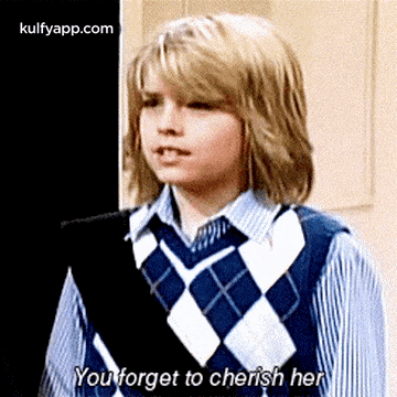 a young boy wearing a plaid vest and tie is talking to another young boy .
