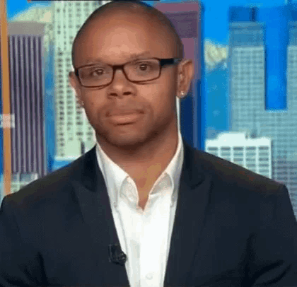a man in a suit and glasses is making a funny face .