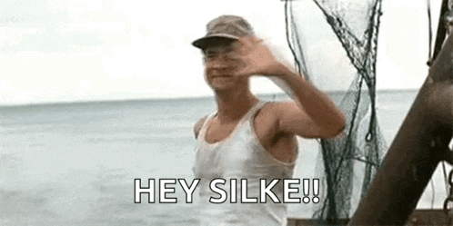 a man is standing on a boat in the ocean and waving at the camera .