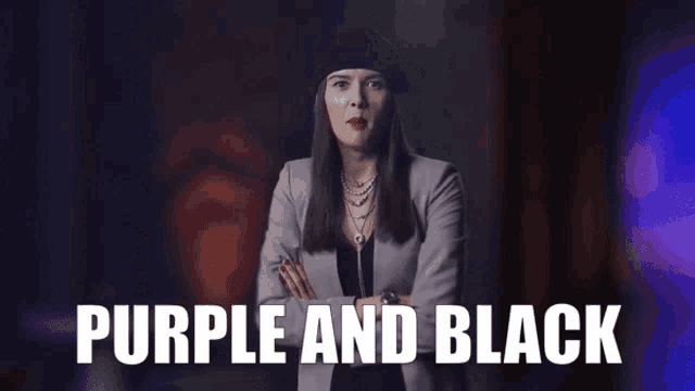 a woman with her arms crossed is standing in front of a sign that says purple and black