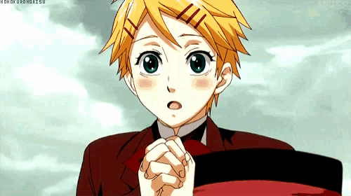 a young boy with blonde hair and blue eyes is wearing a red suit and tie .