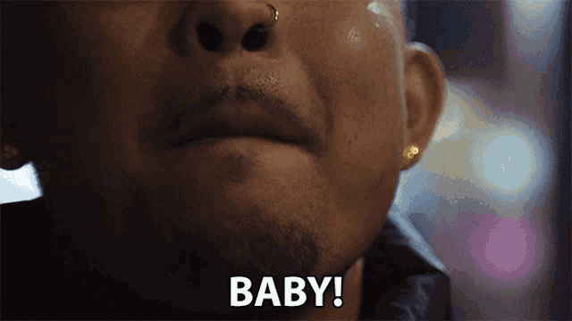 a close up of a man 's face with the word baby on the bottom