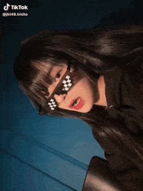 a tiktok video of a girl wearing sunglasses with a checkered pattern on them