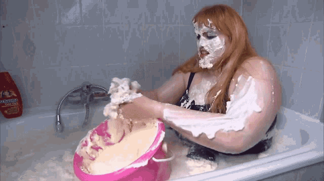 a woman in a bathtub with her face covered in whipped cream is holding a pink bowl