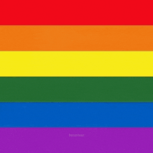 a man and a woman are standing next to each other with a rainbow flag in the background