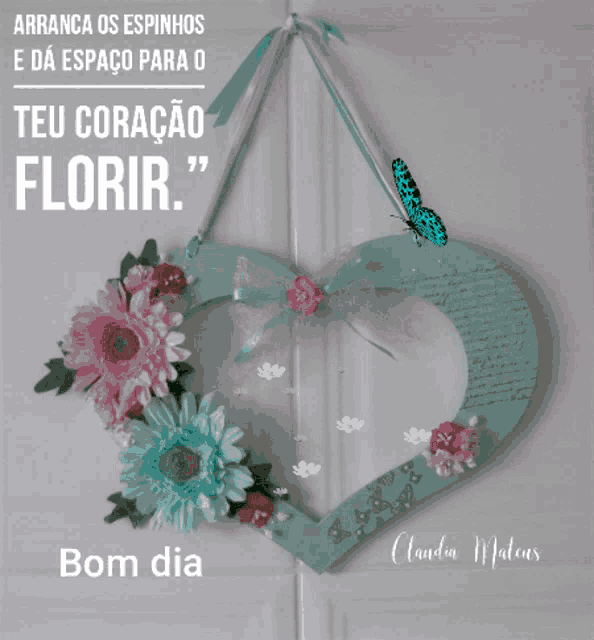 a heart shaped wreath with flowers and a blue butterfly says bom dia