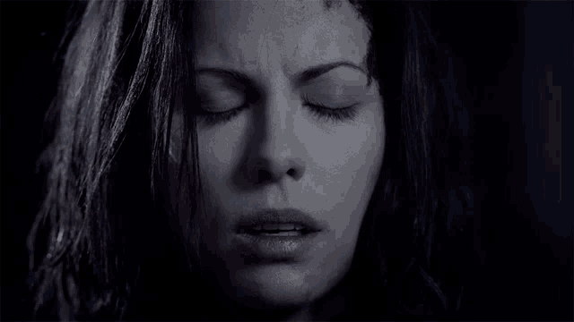 a woman with her eyes closed has blood on her forehead