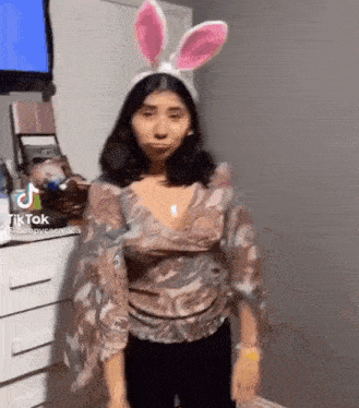a woman is wearing bunny ears and making a face .