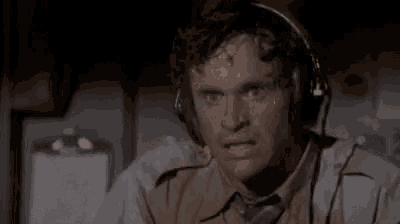 a man wearing headphones and sweating while sitting on an airplane .