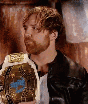 a man with a beard is holding a championship belt .