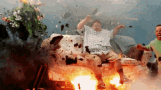 a man is sitting on a couch in front of a couch that is on fire