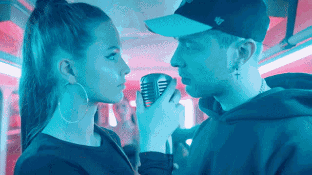 a man wearing a 47 hat is holding a microphone to his face