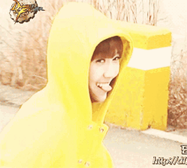 a woman wearing a yellow hoodie with the letters e on the back