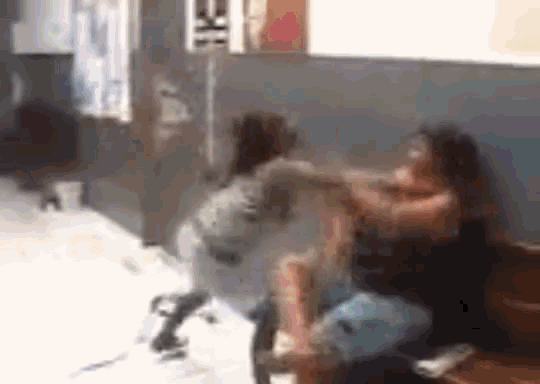 a blurry photo of two women fighting in a room .