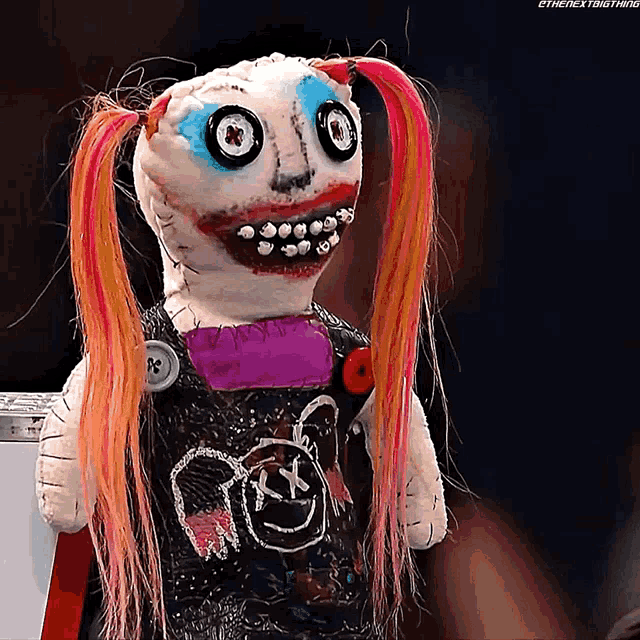 a stuffed doll with pigtails and a shirt that says ' x ' on it