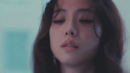 a close up of a woman 's face with her eyes closed and a blurry background .
